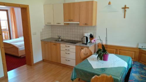 a kitchen with a table and a cross on the wall at Oberlindnerhof in San Lorenzo di Sebato