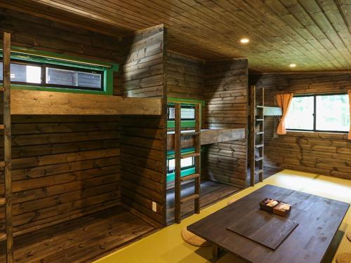 Zimmer mit einem Tisch in einer Holzhütte in der Unterkunft Japanese Cottage Nagomiya seseragi in Gujō