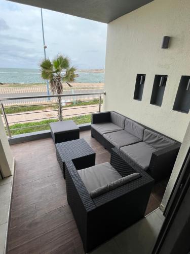 uma sala de estar com um sofá e vista para a praia em Appartement El jadida Sidi Bouzid em Sidi Bouzid