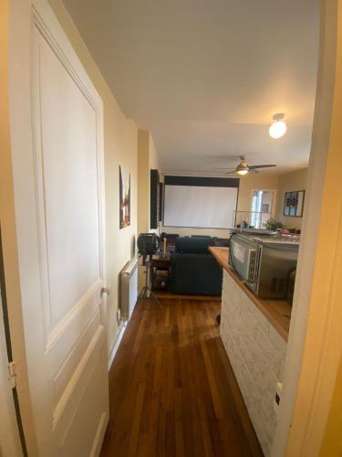 un couloir d'une chambre avec une cuisine et un four micro-ondes dans l'établissement Charmant T2 à 5mn Gare Saint Denis, à Saint-Denis