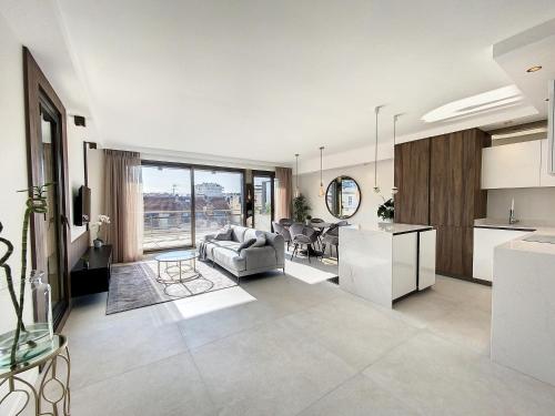 une cuisine et un salon avec un canapé et une table dans l'établissement GRA6B - Gray d'Albion, 3 pièces avec terrasse, à Cannes