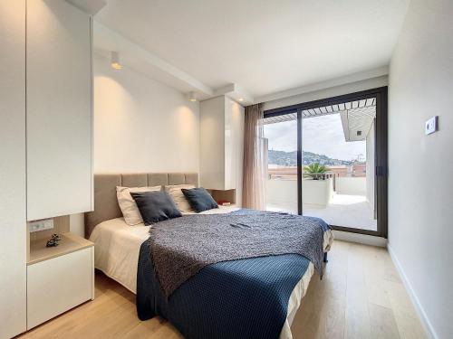 une chambre avec un lit et une grande fenêtre dans l'établissement GRA6B - Gray d'Albion, 3 pièces avec terrasse, à Cannes