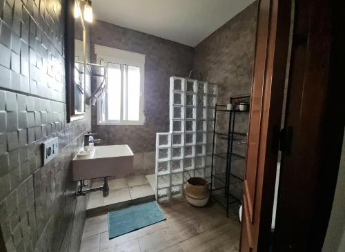 a bathroom with a sink and a shelf at Girasoles in Chiclana de la Frontera