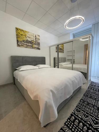 a bedroom with a large white bed and a mirror at TLux in Stolac