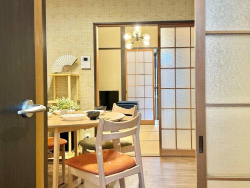 a dining room with a table and chairs and a door at Rakuyado kyotofushimi II in Kyoto