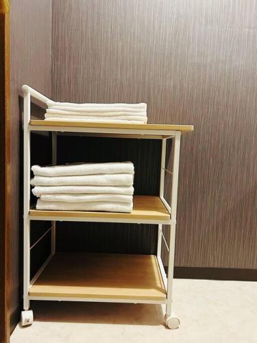 a shelf with white towels on top of it at Rakuyado kyotofushimi I in Kyoto