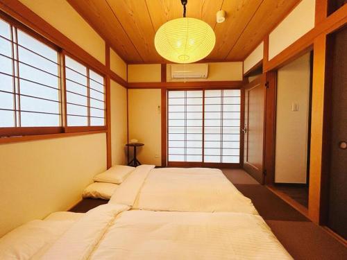 a room with two beds in it with windows at Rakuyado kyotofushimi I in Kyoto