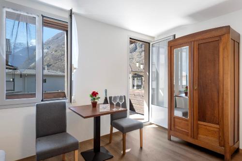 Habitación con mesa, sillas y ventanas. en Casa Al Torchio 1,2,3 and 4 - Happy Rentals en Cavergno