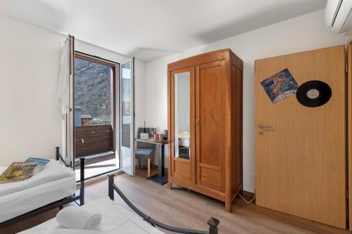 a bedroom with a bed and a cabinet and a window at Casa Al Torchio 1,2,3 and 4 - Happy Rentals in Bignasco