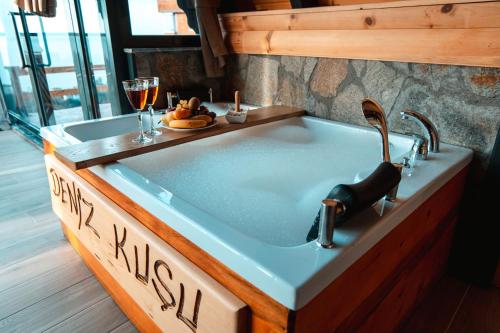 a bath tub with a sink in a room at Denizkuşu Bungalov in Rize