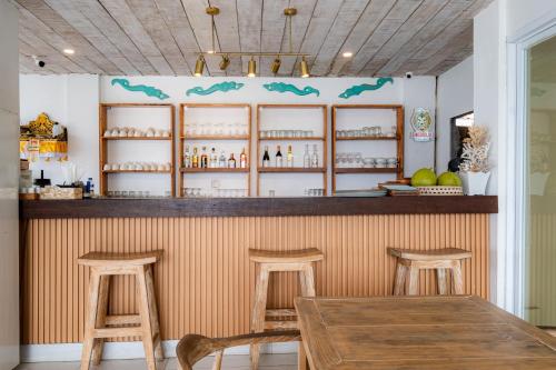 a bar with two wooden stools and a wooden table at AMP Beach House in Nusa Penida