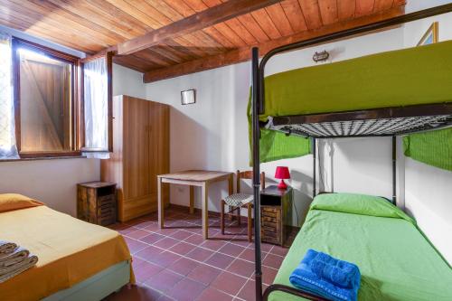 a bedroom with two bunk beds and a desk at Il mare in tasca in San Vero Milis