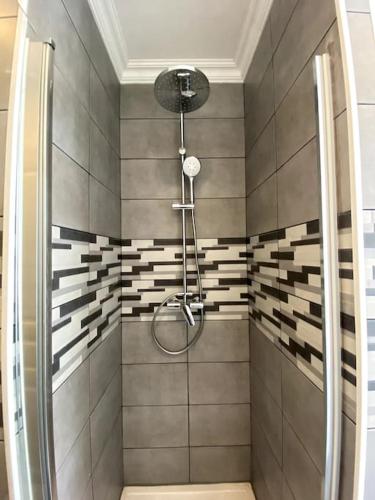 une salle de bain avec une douche avec pommeau de douche dans l'établissement Maison en plein centre-ville, à Châteauroux