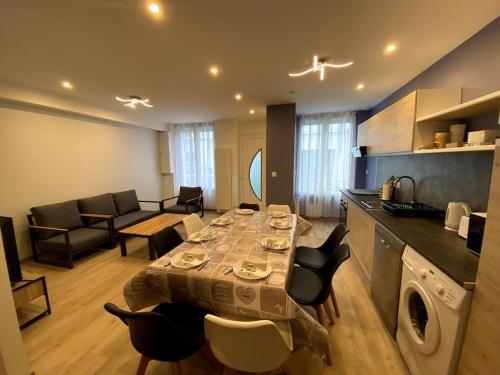 Il comprend un salon avec une table et des chaises ainsi qu'une cuisine. dans l'établissement Maison en plein centre-ville, à Châteauroux