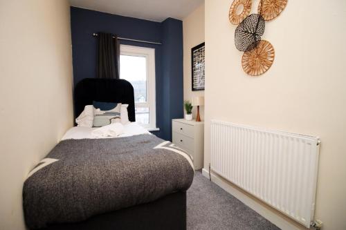 1 dormitorio con cama y ventana en Cosy 3BR Home, Scenic Views, Ideal for Walks & Work, en Abertillery
