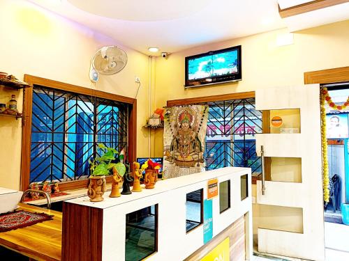 a living room with a tv and stained glass windows at The Amber in Durgāpur
