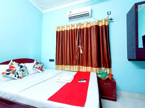 a bedroom with a bed with a red curtain at Jo'stel Amber in Durgāpur