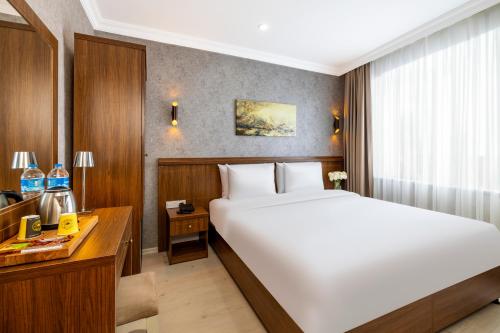 ein Hotelzimmer mit einem großen Bett und einem Schreibtisch in der Unterkunft Diamond Beyazit Hotel in Istanbul