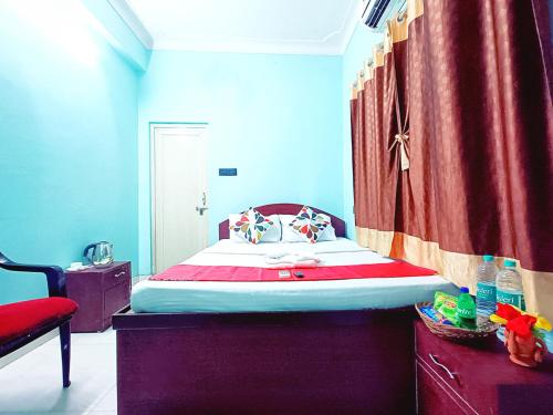 a bedroom with a bed and a red curtain at Jo'stel Amber in Durgāpur