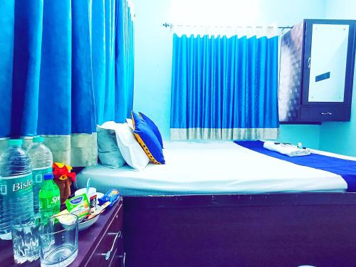 a blue room with a bed with blue curtains at Jo'stel Amber in Durgāpur