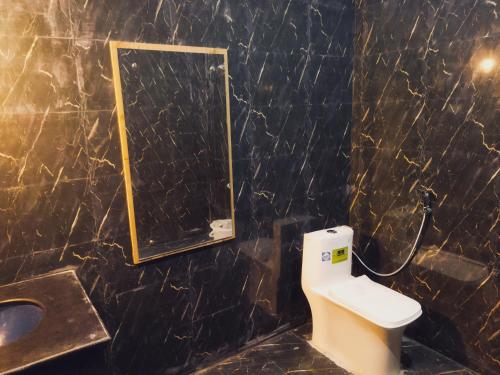 a bathroom with a sink and a toilet and a mirror at Hotel Hara Rama Hare Krishna Rameswaram in Rāmeswaram