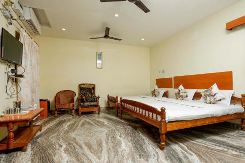 a bedroom with a bed and a desk and a tv at Hotel Hara Rama Hare Krishna Rameswaram in Rāmeswaram