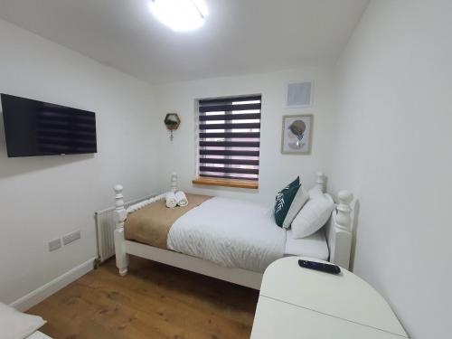 a white bedroom with a bed and a window at 1. Single Room (Professional, Trades) Welcome in Luton