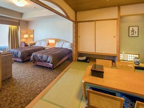 een hotelkamer met 2 bedden en een bureau bij LiVEMAX RESORT Hakodate Greenpia Onuma in Mori