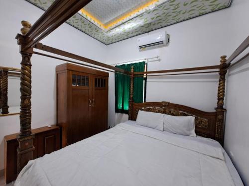 - une chambre avec un lit doté d'un cadre en bois dans l'établissement OYO 93814 Amanda Homestay, à Bandar Lampung