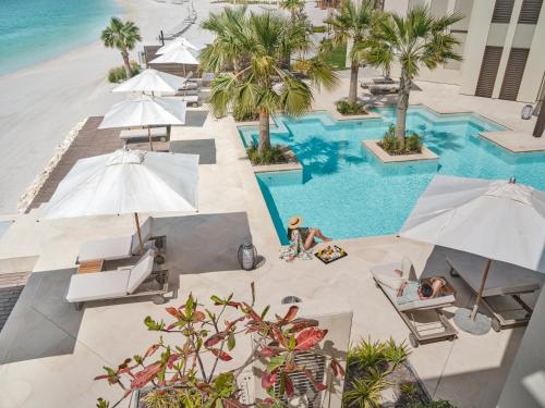 an overhead view of a resort pool with umbrellas at Jumeirah Gulf of Bahrain in Manama