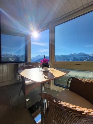 a dining room with a table and a large window at Hotelwohnung Superior-Suite in Beatenberg