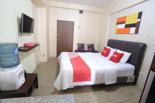 a bedroom with a large bed with red pillows at OYO 93825 Nona Key Property in Bekasi