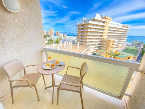 a balcony with a table and chairs and a view of the ocean at MS Aguamarina Suites in Torremolinos