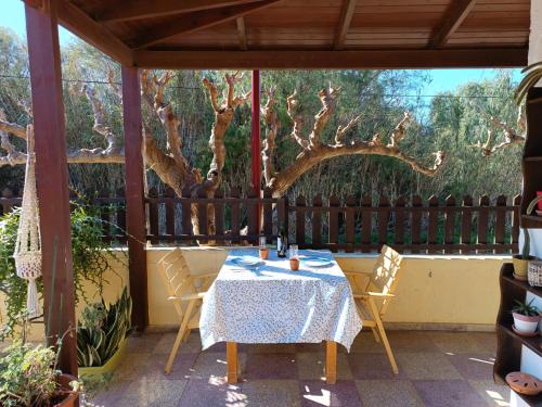 a table and chairs on a patio with a tree at Golden Horizon Retreat, 2 min walk from the sea! in Gournes