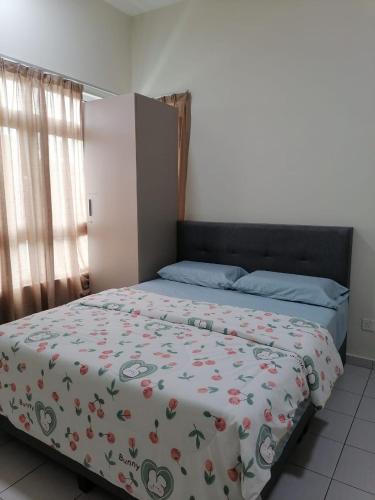 a bedroom with a bed with a floral comforter at Enjoy the sunset @ Bright mesahill condo in Nilai