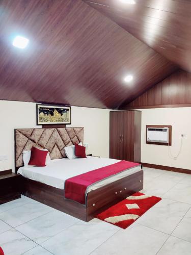 a bedroom with a large bed with a red blanket at Shiva Green Valley Farms in Bikaner