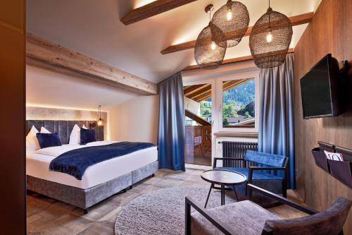 a hotel room with a bed and a living room at SOULSISTERS' Hotel in Kaprun