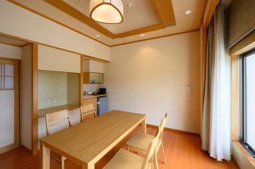 a dining room with a wooden table and chairs at Hotel Symphony Annex Sagae Onsen in Sagae