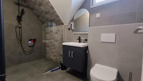 a bathroom with a shower and a toilet and a sink at Guest House Green Field in Sarajevo