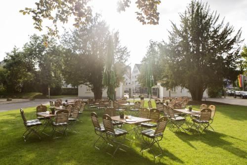 un grupo de mesas y sillas en el césped en Novotel Hildesheim, en Hildesheim