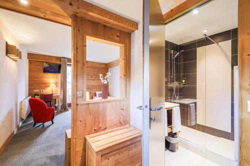 baño con ducha y puerta de madera en Hôtel et Spa les Clarines en Corrençon-en-Vercors