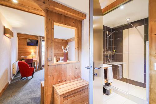 ein Badezimmer mit einer Dusche und einer Holztür in der Unterkunft Hôtel et Spa les Clarines in Corrençon-en-Vercors