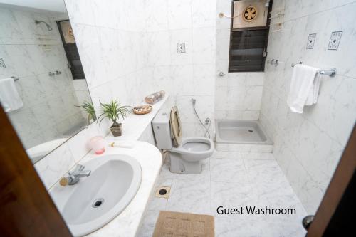 een badkamer met een toilet, een wastafel en een bad bij Swarloke Apartment at Gulshan 2,Dhaka in Dhaka