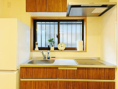 a kitchen with a sink and a window with a clock at Meet Inari in Kyoto