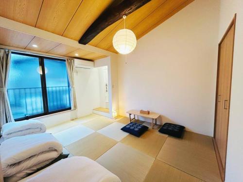 a bedroom with two beds and a large window at Meet Inari in Kyoto