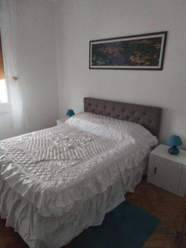 a bedroom with a bed and a picture on the wall at Appartament holidays Sistiana in Sistiana