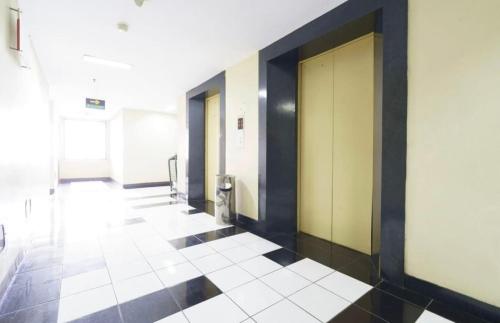 a hallway of an office building with doors and tile floors at OYO 93857 Apartemen Kalibata City By Artomoro in Jakarta