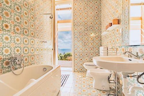 カポリーヴェリにあるVilla Acquarilliのバスルーム(バスタブ、シンク、トイレ2つ付)