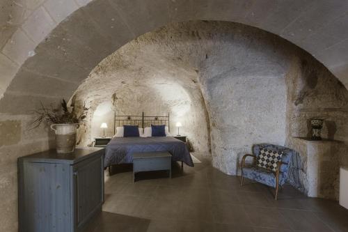 a bedroom with a bed in a stone wall at Le Dodici Lune in Matera
