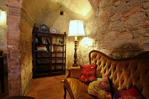 a living room with a couch in a stone wall at Agriturismo Le Spighe in Proceno